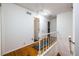 Hallway featuring hardwood floors, white walls, and a blue patterned rug, leading to multiple rooms at 5410 Rosser Rd, Stone Mountain, GA 30087