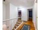 Upper level hallway showcasing hardwood floors, staircase with a white railing, and access to bedrooms at 5410 Rosser Rd, Stone Mountain, GA 30087
