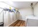 Well-lit laundry room with washer, dryer, hanging rack, and laminate flooring at 5410 Rosser Rd, Stone Mountain, GA 30087