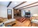 Bright living room with brick fireplace, wooden beams, and hardwood floors at 5410 Rosser Rd, Stone Mountain, GA 30087