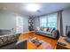 Inviting living room with hardwood floors, comfortable seating, shelving, and a bright window at 5410 Rosser Rd, Stone Mountain, GA 30087