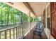 Relaxing covered porch with seating, offering a serene view of the surrounding trees and landscaped yard at 5410 Rosser Rd, Stone Mountain, GA 30087