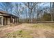 View of the backyard with patio, unfenced yard, and mature trees at 108 Deer Creek Run, Moreland, GA 30259