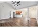 Open-concept living room with wood floors, ceiling fan, stylish lighting and views of the kitchen at 108 Deer Creek Run, Moreland, GA 30259