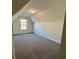 Upstairs bedroom featuring neutral walls, plush carpeting, a sloped ceiling, and a window for natural light at 3806 Lockaby Way, Lawrenceville, GA 30044