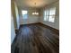 Bright dining room featuring wood floors, panelled walls, two windows, and a chandelier at 3806 Lockaby Way, Lawrenceville, GA 30044