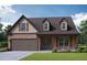 Charming two-story home with brick facade, dormer windows, well-kept lawn, and an attached garage at 3806 Lockaby Way, Lawrenceville, GA 30044
