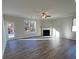 Open living room featuring hardwood floors, a fireplace, ceiling fan, and natural light at 3806 Lockaby Way, Lawrenceville, GA 30044