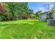 Vast green backyard, surrounded by lush trees, featuring a shed, an AC unit, and a spacious grass-covered space at 57 Fair Oaks Se Dr, Conyers, GA 30094