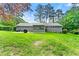 Lush green backyard with patio, grill, screened porch, and house exterior surrounded by trees at 57 Fair Oaks Se Dr, Conyers, GA 30094