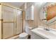Cozy bathroom with shower, toilet, sink, and a cabinet, featuring floral wallpaper and leaf-shaped mirror at 57 Fair Oaks Se Dr, Conyers, GA 30094