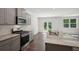 Modern kitchen features a breakfast bar, stainless steel appliances, and gray cabinets at 62 Hampton Ter, Dallas, GA 30157