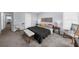 Cozy bedroom with carpet, neutral walls, and a comfortable bed next to a desk and a rocker at 1359 Chatley Way, Woodstock, GA 30188