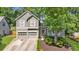Charming two-story home features a two-car garage, arched entryway, and beautifully landscaped front yard at 1359 Chatley Way, Woodstock, GA 30188