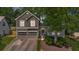 Charming two-story home features a two-car garage, arched entryway, and beautifully landscaped front yard at 1359 Chatley Way, Woodstock, GA 30188