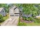 Charming two-story home features a two-car garage, arched entryway, and beautifully landscaped front yard at 1359 Chatley Way, Woodstock, GA 30188