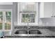 Kitchen sink area with granite counters and view through windows, offering natural light for doing chores at 1359 Chatley Way, Woodstock, GA 30188