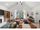 Bright living room with a fireplace, large windows, and stylish furniture arrangement creates a comfortable gathering space at 1359 Chatley Way, Woodstock, GA 30188