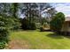 Large backyard with lush green lawn, mature trees, and wooden deck at 3802 Birchbriar Ct, Decatur, GA 30034
