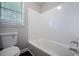 Bathroom with a standard bathtub, toilet and window, providing a clean and functional space at 3802 Birchbriar Ct, Decatur, GA 30034