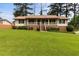 Ranch-style home featuring a brick foundation, covered porch, and a large, well-maintained lawn at 3802 Birchbriar Ct, Decatur, GA 30034
