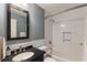Stylish bathroom featuring subway tile shower, dark vanity with black countertop, and chrome fixtures at 4243 Mcclatchey Ne Cir, Atlanta, GA 30342