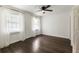 Bright bedroom with dark hardwood floors, ceiling fan, and windows dressed with sheer curtains at 4243 Mcclatchey Ne Cir, Atlanta, GA 30342