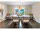 Dining room with hardwood floors features a table for six, large windows, and a modern pendant light fixture at 4243 Mcclatchey Ne Cir, Atlanta, GA 30342