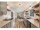 Updated galley kitchen features stainless steel appliances, white cabinets, open shelves, and hardwood-look floors at 4243 Mcclatchey Ne Cir, Atlanta, GA 30342