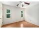 Well-lit bedroom featuring hardwood floors, a ceiling fan, and views of mature trees at 106 Waterford Place Pl, Acworth, GA 30101