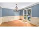 Formal dining room features beautiful blue walls, elegant chandelier, and natural light from a window at 106 Waterford Place Pl, Acworth, GA 30101