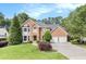 Beautiful brick home with a well-manicured lawn, mature trees, and an attached two car garage at 106 Waterford Place Pl, Acworth, GA 30101