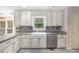 Bright kitchen with stainless steel dishwasher, large farmhouse sink and white cabinets at 106 Waterford Place Pl, Acworth, GA 30101