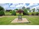 Well maintained backyard with lush landscaping, mature trees, fire pit and white fencing at 110 Amsterdam Dr, Lilburn, GA 30047