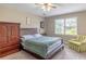 Spacious bedroom with large wardrobe, ceiling fan, queen bed, and a window overlooking the backyard at 110 Amsterdam Dr, Lilburn, GA 30047