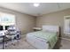 Well-lit bedroom with a large window, desk, chair and a queen bed with green bedding at 110 Amsterdam Dr, Lilburn, GA 30047
