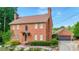 Beautiful two-story brick home with a detached garage and lush green landscaping at 110 Amsterdam Dr, Lilburn, GA 30047