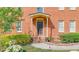 Close-up of the brick home's entryway, complemented by flowering bushes and manicured shrubbery at 110 Amsterdam Dr, Lilburn, GA 30047