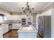 Bright kitchen with stainless steel appliances, white cabinetry, and island with tile countertop at 110 Amsterdam Dr, Lilburn, GA 30047