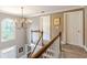 Bright landing area with wood railing, chandelier and a large arched window at 110 Amsterdam Dr, Lilburn, GA 30047