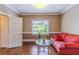 Cozy living room with hardwood floors, natural light, and comfortable red sofa at 110 Amsterdam Dr, Lilburn, GA 30047