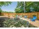 Backyard fire pit area with Adirondack chairs, landscaping, and a wooden fence at 2304 Mitford Ct, Dacula, GA 30019