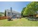 Spacious backyard with a lush green lawn, mature trees, a patio area, and hot tub at 2304 Mitford Ct, Dacula, GA 30019
