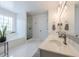Bright bathroom with double sink vanity, soaking tub, glass enclosed shower and white tile floors at 2304 Mitford Ct, Dacula, GA 30019