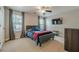 Neutral-toned bedroom with ceiling fan, large windows, and a comfortable bed with blue bedding and an orange throw at 2304 Mitford Ct, Dacula, GA 30019