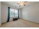 Bright bedroom with a ceiling fan, neutral carpet, and a window with a backyard view at 2304 Mitford Ct, Dacula, GA 30019