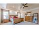Beautiful main bedroom features a tray ceiling, ceiling fan, textured wall and wooden bedroom set at 2304 Mitford Ct, Dacula, GA 30019