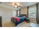 Bright, comfortable bedroom with large windows, ceiling fan, and comfortable bed with gray headboard at 2304 Mitford Ct, Dacula, GA 30019