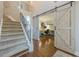 Bright foyer with hardwood floors, staircase, and a sliding barn door leading to the office at 2304 Mitford Ct, Dacula, GA 30019