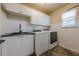 Functional laundry room with washer, dryer, utility sink, and storage cabinets at 2304 Mitford Ct, Dacula, GA 30019